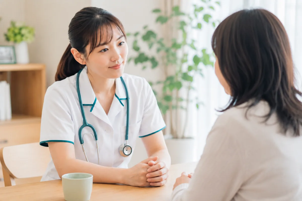 テーブルで向き合い話を聴く看護師